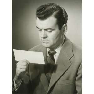 Studio Shot of Mid Adult Man Looking at Piece of Paper Photographic 