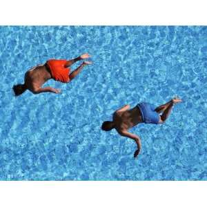  Two Young Men Jump from a Tower in an Outdoor Swimming Arena 