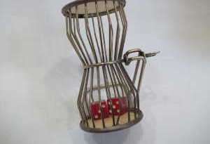 Old metal cage dice hand spinner with stand. Silver with red dice.